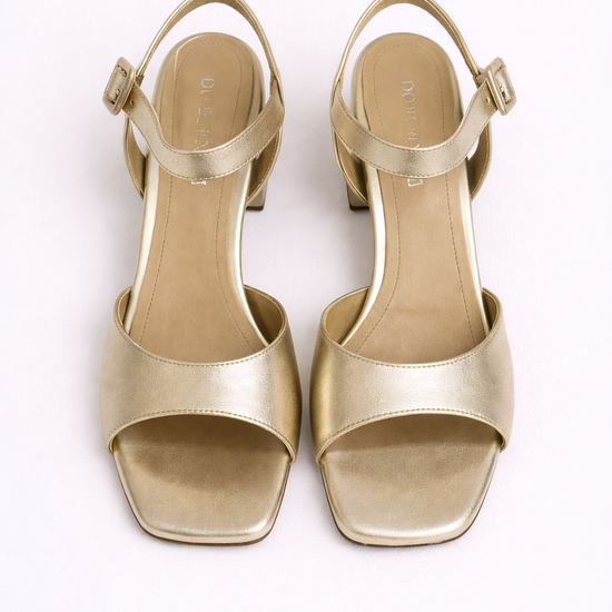 Gold high-heeled sandals on a white background