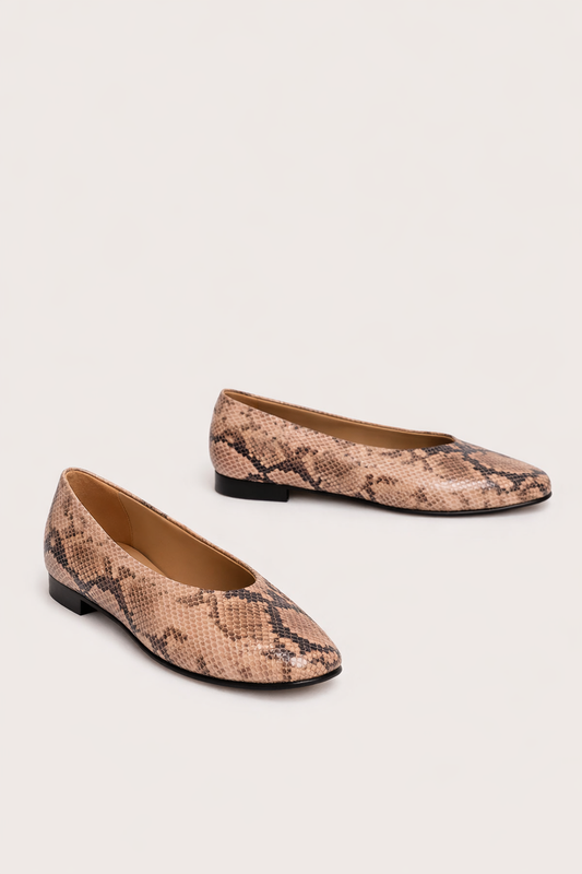 Pair of snake print flats on a light background