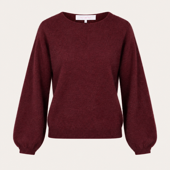A long-sleeve crewneck sweater in a deep burgundy color, displayed against a solid off-white background.