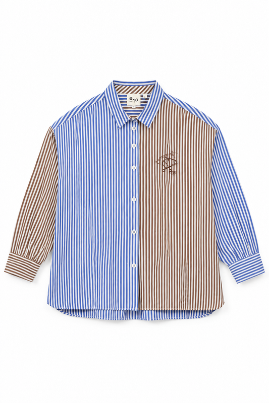 A long-sleeve button-up shirt with a split design: one half features vertical blue and white stripes, and the other half features vertical brown and white stripes. It has a small embroidered logo on the left chest and a visible 'sps' brand label inside the collar.