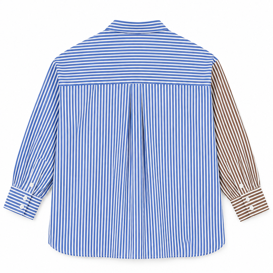 A long-sleeve button-up shirt shown from the back, featuring vertical blue and white stripes on the main body, a solid blue horizontal stripe across the upper back, and brown and white vertical stripes on the right sleeve.
