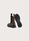 A pair of brown leather Chelsea-style boots shown from the back, with one boot standing upright to display the black elastic side panel and pull tab, and the other lying on its side to show the black lug sole. The brand name 'BRUN' is embossed on the heel and printed on the outsole.