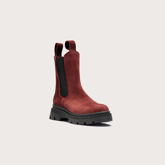 A single dark red suede Chelsea-style ankle boot with black elastic side panels and a chunky black sole, shown on a light gray background.