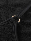Close-up of a black textured fabric with a gold ring detail.