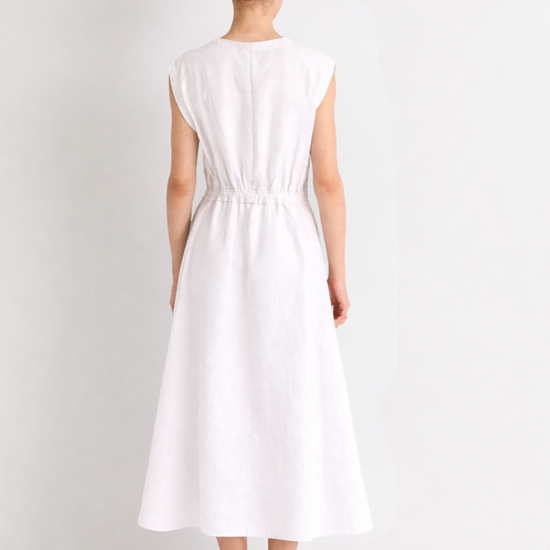 Woman wearing a white linen dress against a plain background from Mei meiJ