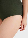 Close up of leg on green one size swimsuit