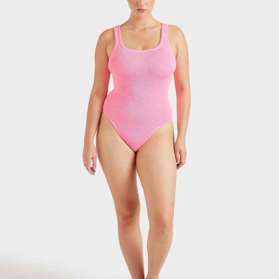 Woman wearing a pink swimsuit on a white background