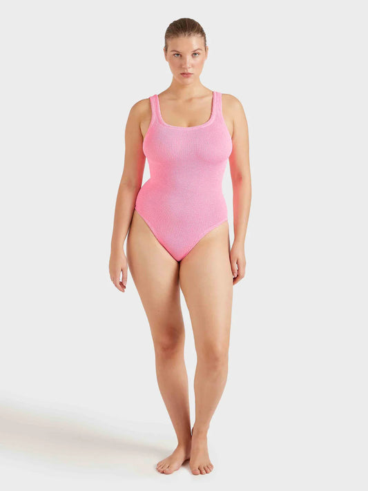 Woman wearing a pink swimsuit on a white background