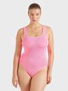 Woman wearing a pink ribbed swimsuit on a white background