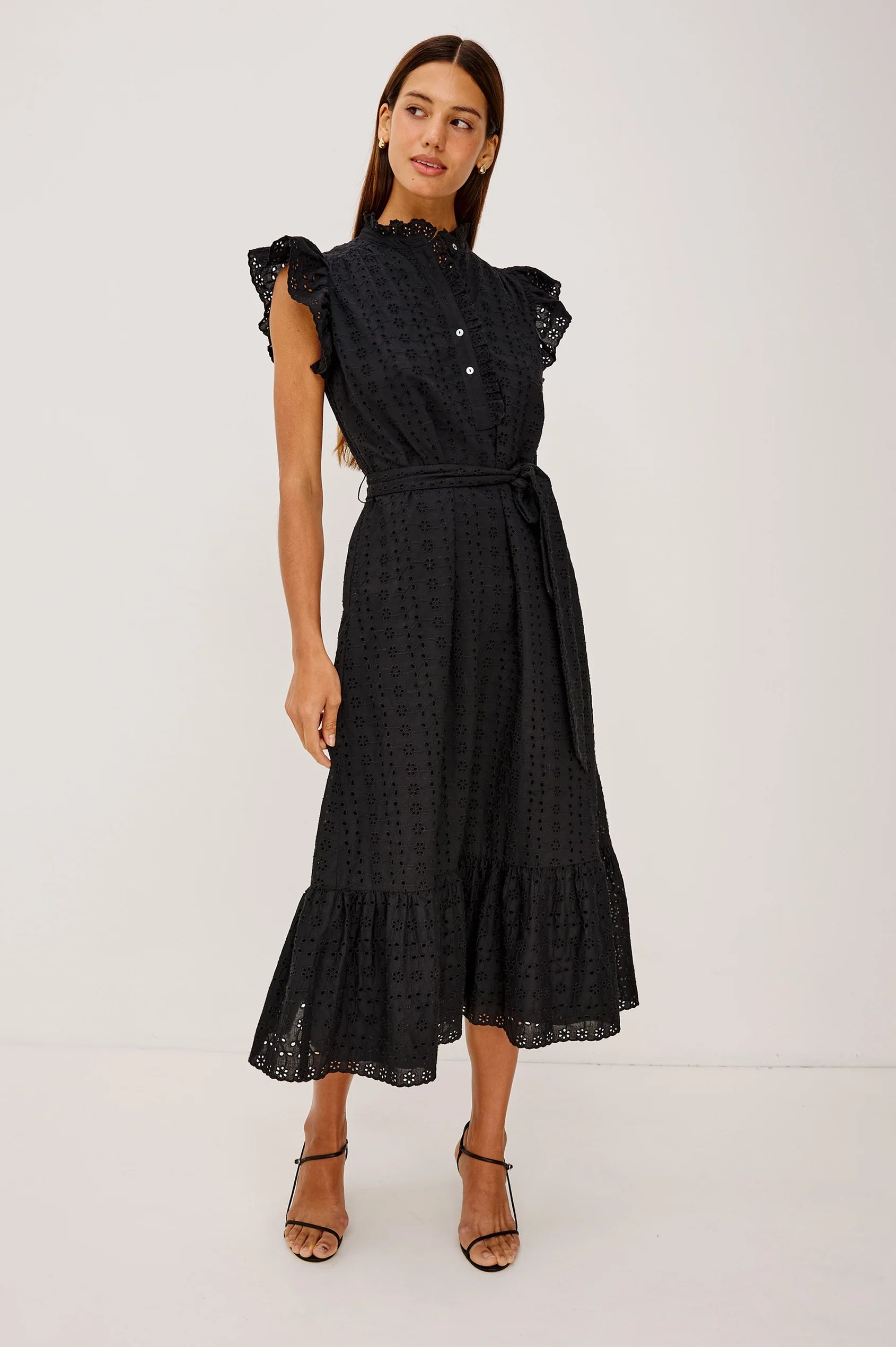 Woman wearing a black dress with ruffled sleeves on a white background from rails
