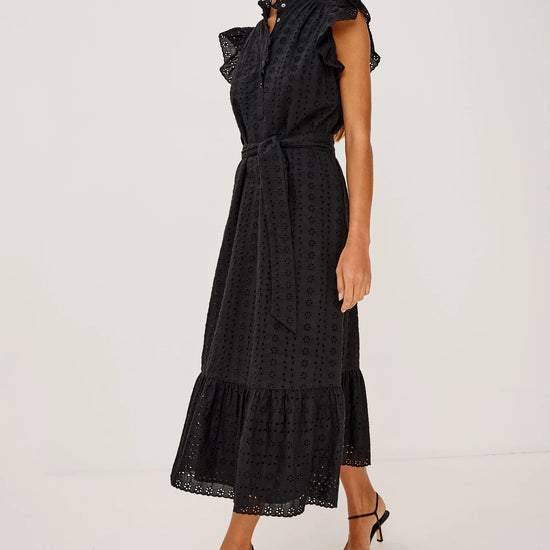 Woman wearing a black dress with ruffled details on a white background