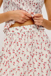 Person wearing a floral skirt with a close-up of the waistband.