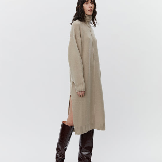 Beige wool dress with a funnel neck and long sleeves model shot with boots