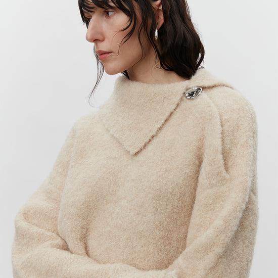 Cream boucle wool jumper with asymetric neckline detail close up