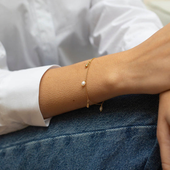 Delicate gold bracelet with pearl and gold teardrop charms