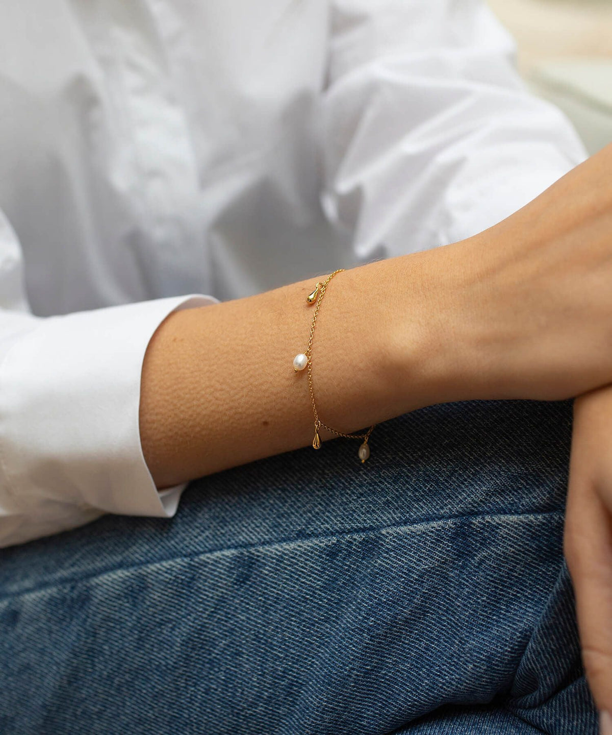 Delicate gold bracelet with pearl and gold teardrop charms