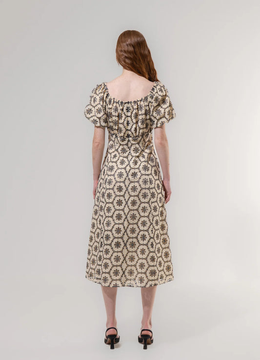 Woman wearing a patterned dress on a plain background