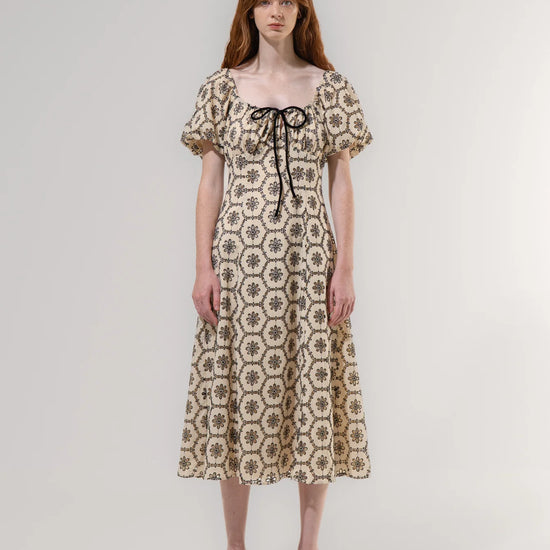 Woman wearing a floral patterned dress on a plain background