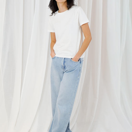 woman wearing white t shirt with blue jeans on white background