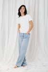 woman wearing white t shirt with blue jeans on white background