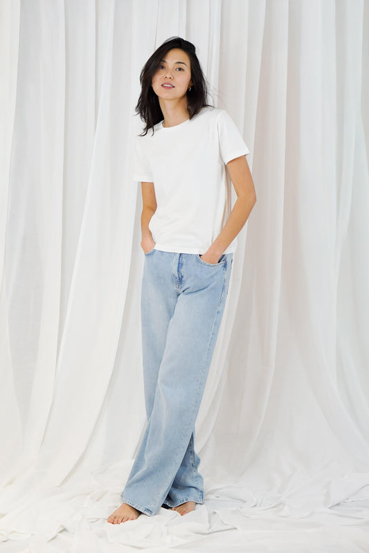 woman wearing white t shirt with blue jeans on white background