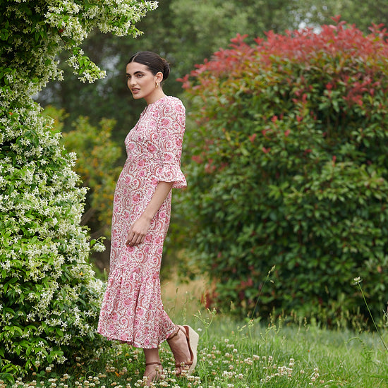 Pink floral midi dress with slash neckline three quarter sleeves with ruffle detail empire line and deep ruffle hem