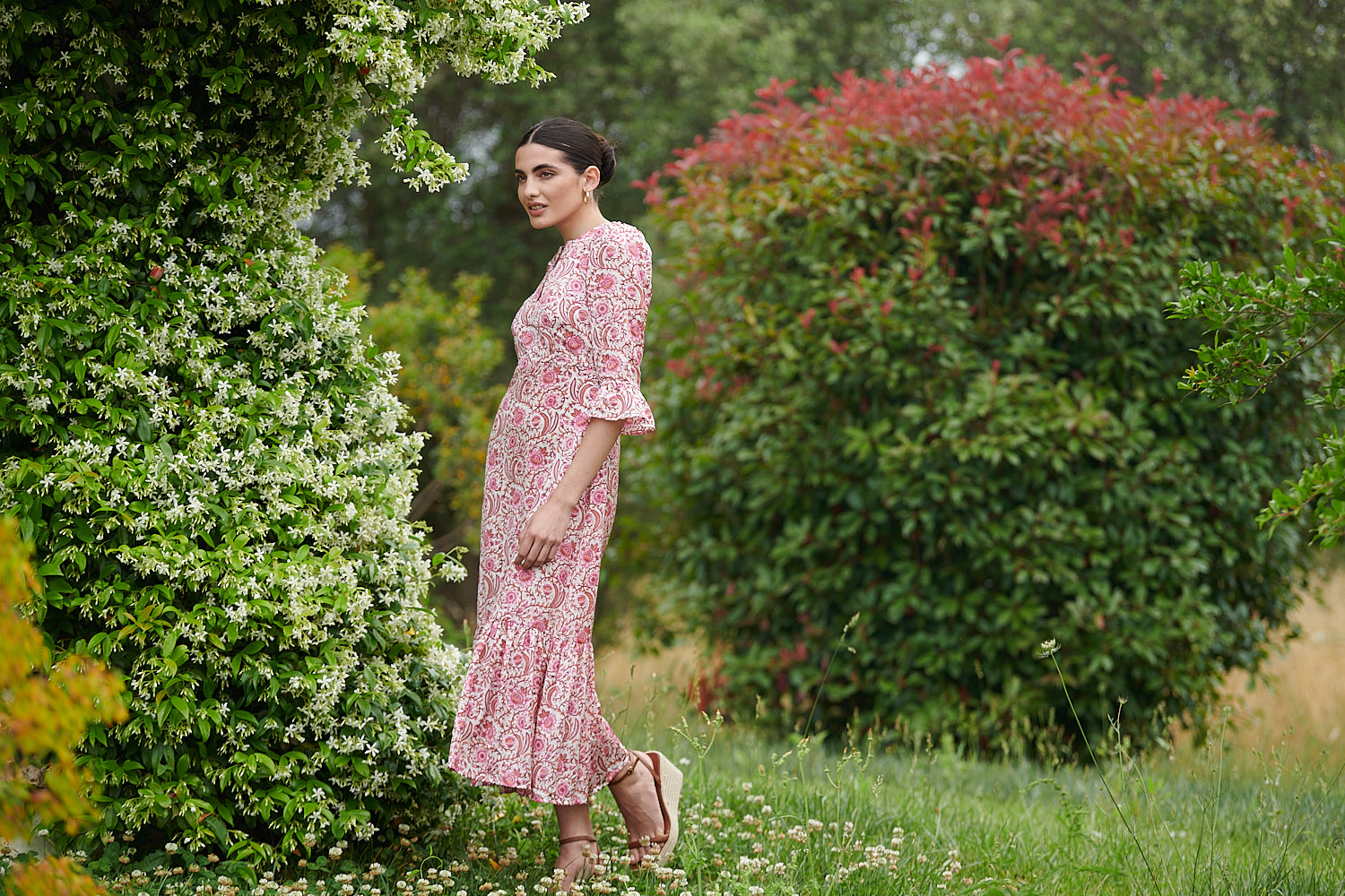 Pink floral midi dress with slash neckline three quarter sleeves with ruffle detail empire line and deep ruffle hem