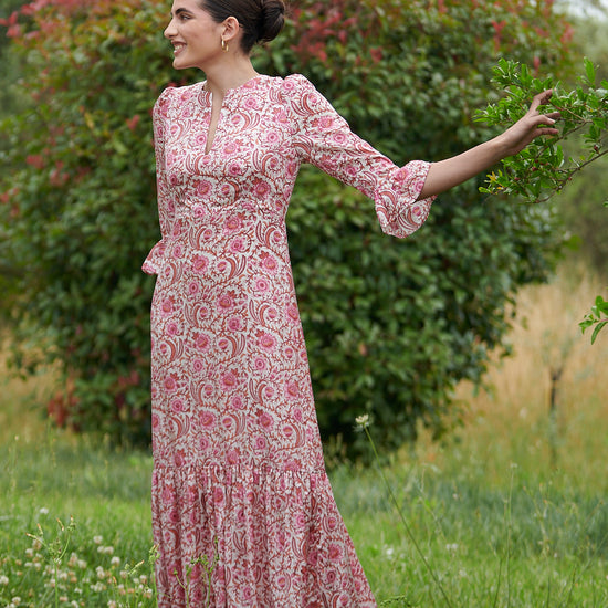 Pink floral midi dress with slash neckline three quarter sleeves with ruffle detail empire line and deep ruffle hem