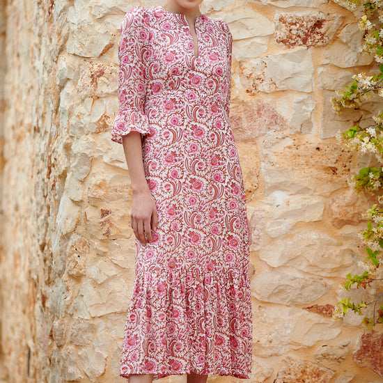 Pink floral midi dress with slash neckline three quarter sleeves with ruffle detail empire line and deep ruffle hem