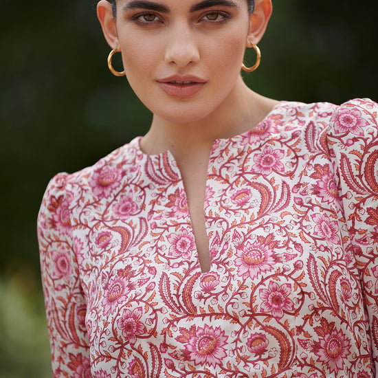 Pink floral midi dress with slash neckline three quarter sleeves with ruffle detail empire line and deep ruffle hem