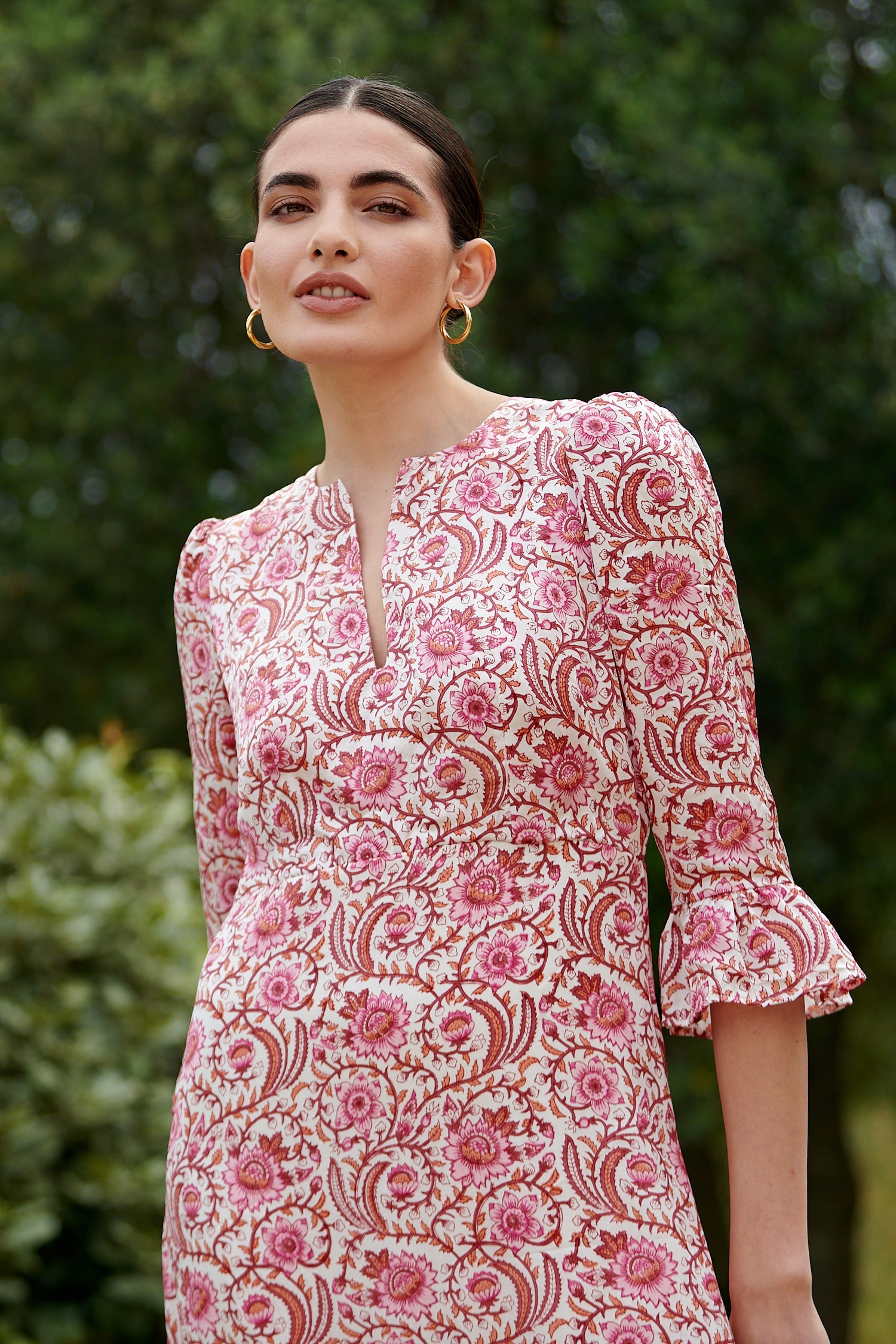 Pink floral midi dress with slash neckline three quarter sleeves with ruffle detail empire line and deep ruffle hem