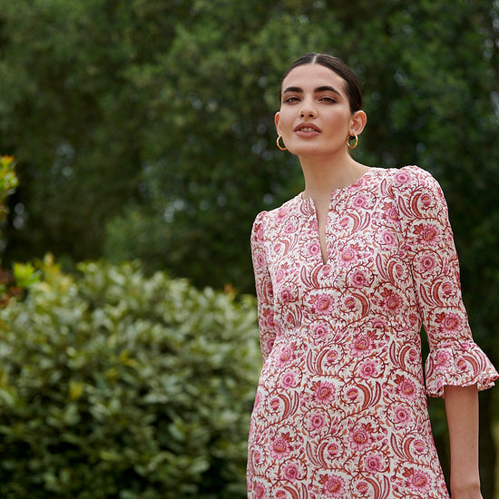 Pink floral midi dress with slash neckline three quarter sleeves with ruffle detail empire line and deep ruffle hem