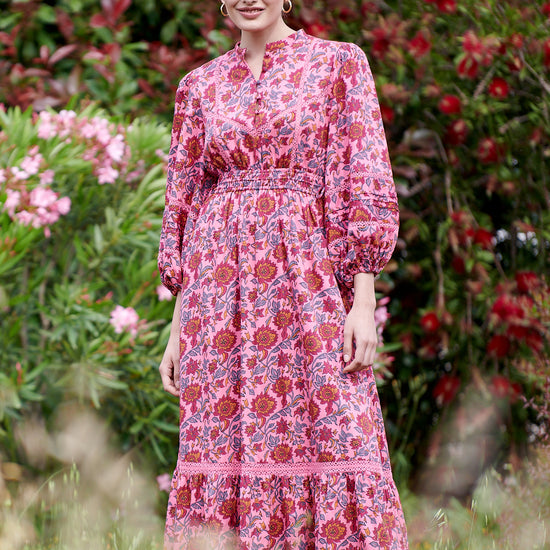 Pink midi dress with floral details with bracelet length sleeves mau collar covered button half placket elasticated waist with drawstring and gathered hem with lace inserts