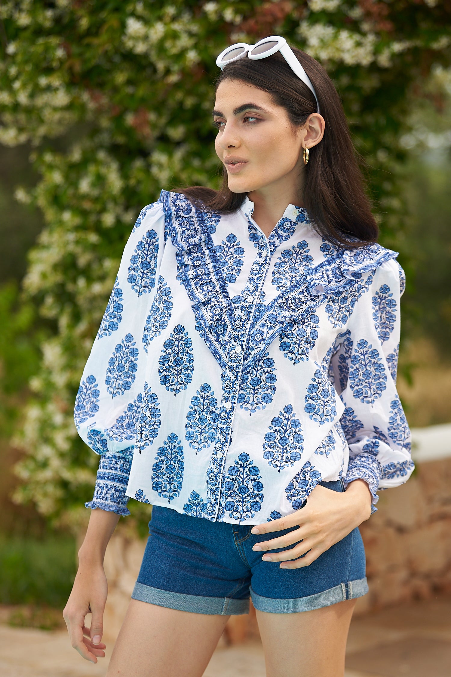 White shirt with mau collar and V shaped ruffle on the yoke with white background and blue floral print and long sleeves