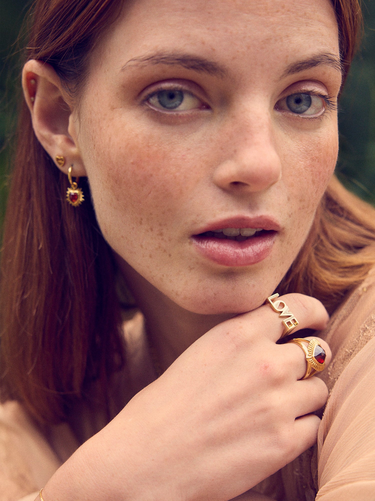 gold spiky heart shaped charm earrings with red stone and huggie hoops from rachel jackson model shot