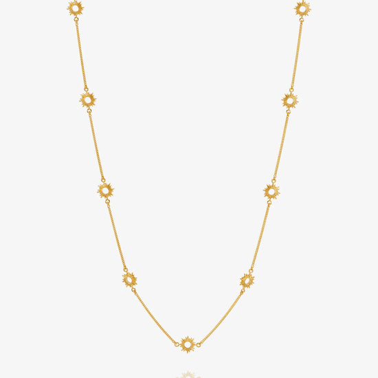 Gold necklace with sUN-shaped detail on a white background