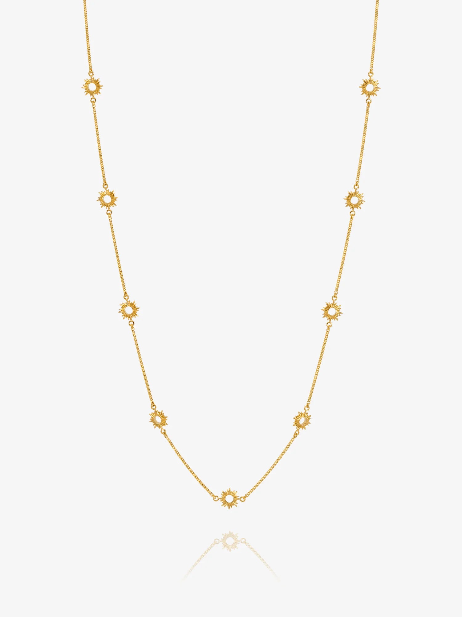 Gold necklace with sUN-shaped detail on a white background