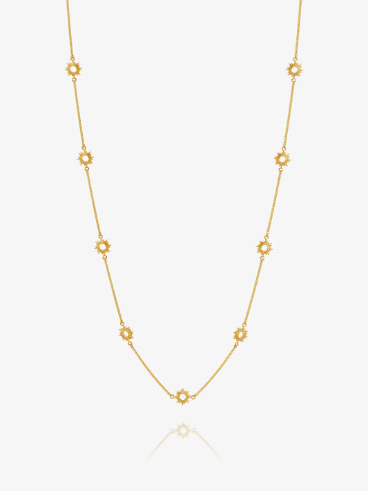Gold necklace with sUN-shaped detail on a white background