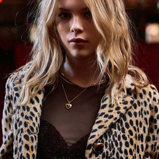 gold heart with red stone inside on a gold chain from rachel jackson model shot