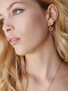 small huggie gold earrings with spiky gold heart charms from rachel jackson  model shot