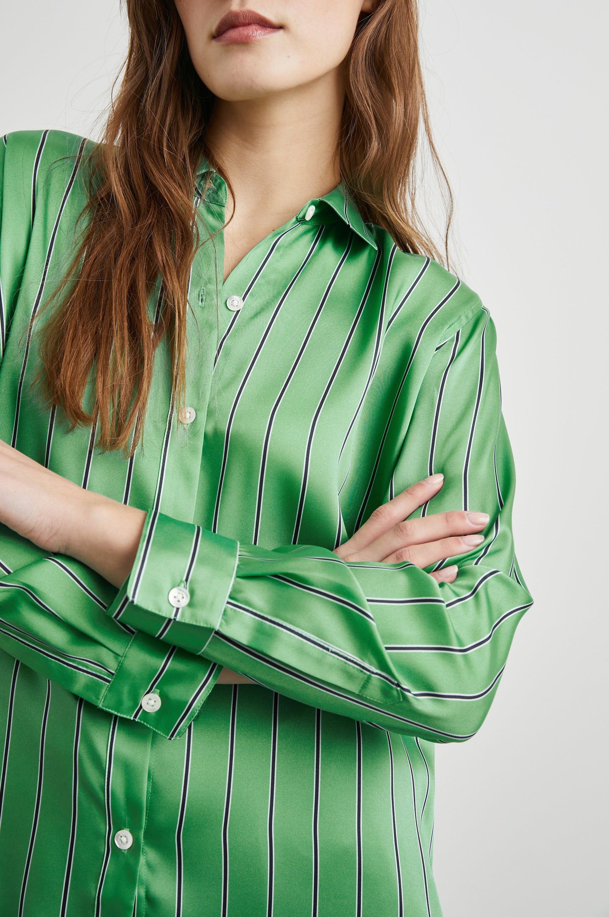 Close up view of button on the Elias stripe shirt in basil green.