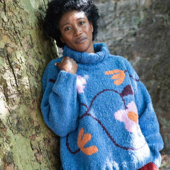 blue roll neck with ribbed cuffs, hem and neck with colourful floral design model shot