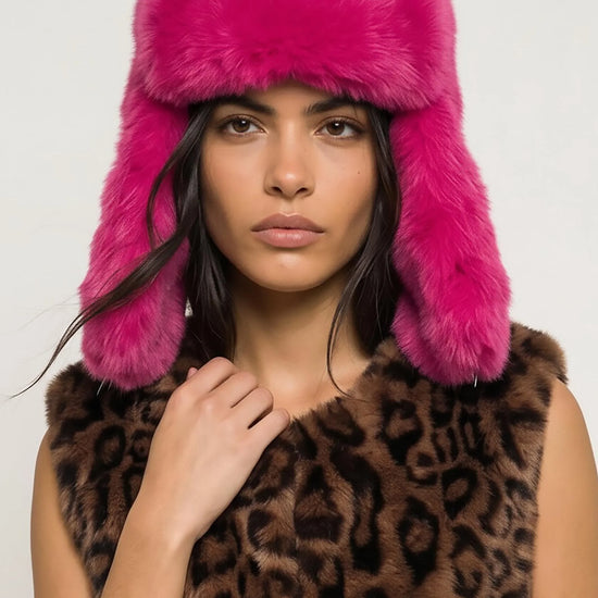 model shot of woman wearing bright pink hat and animal print gillet