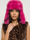 model shot of woman wearing bright pink hat and animal print gillet