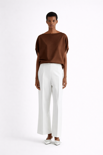 Person wearing a brown top and white pants on a white background from Mei MeiJ