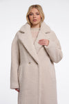 Woman wearing a beige teddy coat on a white background