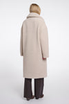 Person wearing a beige coat on a white background