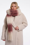 Woman wearing a beige coat and plaid scarf on a white background