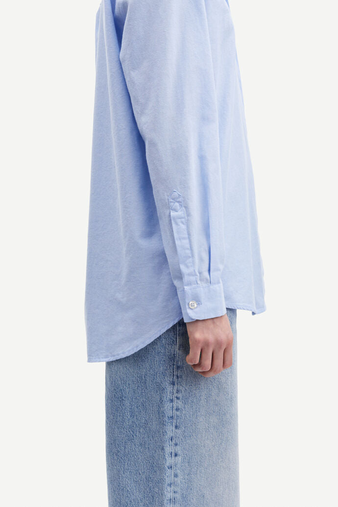 Light blue cotton shirt with long sleeves and full length hidden placket with button fastening