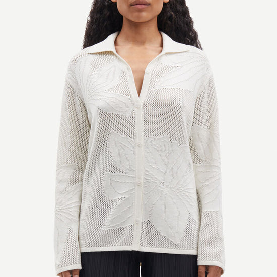 Collared button through knit shirt with floral design within the weave